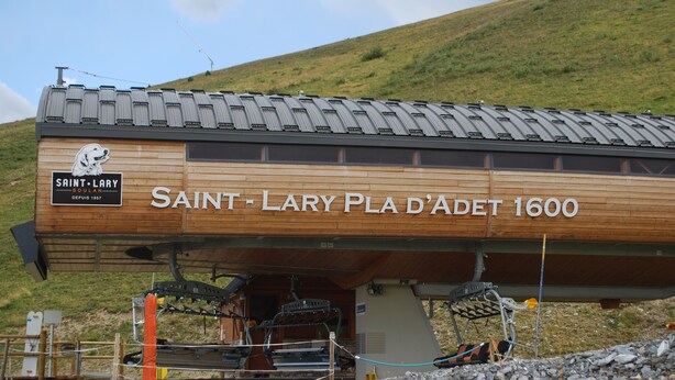 A wooden building labeled "SAINT-LARY PLA D'ADET 1600" with ski lift equipment underneath. - Valley view apartment (Saint-Lary-Soulan)