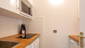 Una cocina compacta equipada con microondas, cafetera y lavavajillas.
