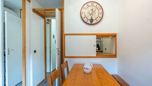 Un comedor con una mesa de madera, sillas, un reloj en la pared y un espejo.