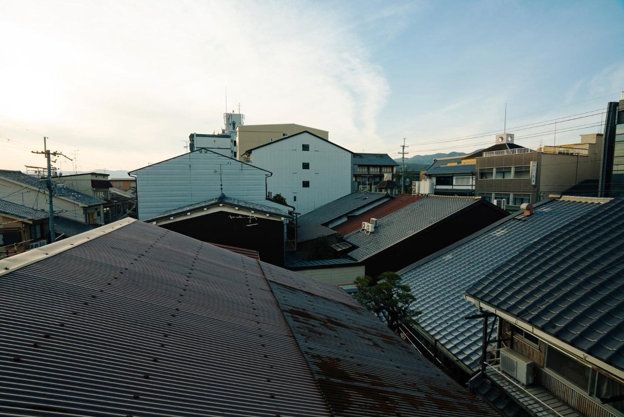 Zona residencial con varios edificios, incluyendo un edificio blanco destacado con techo plano y otro edificio más pequeño con techo inclinado.