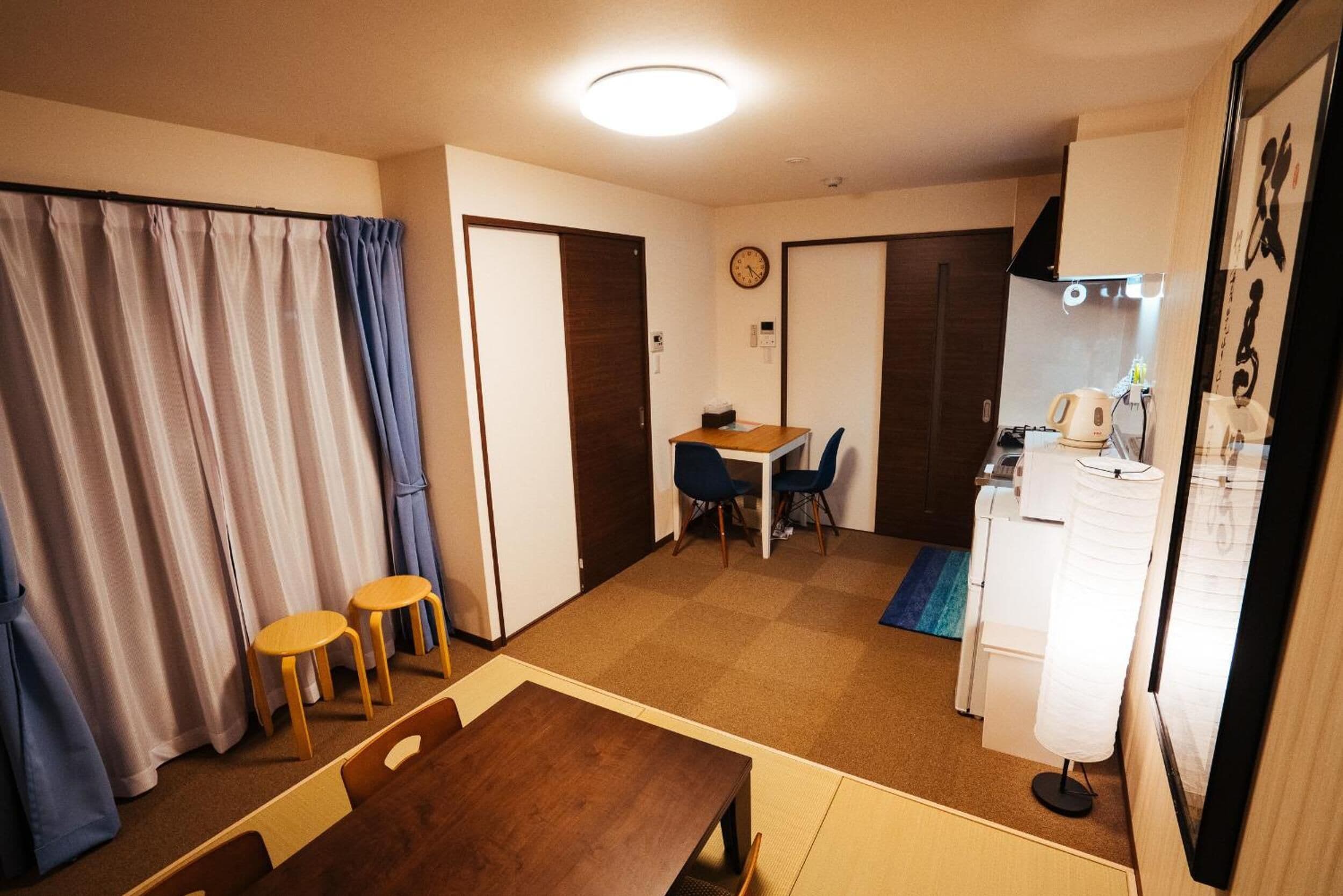 Un espacio habitable compacto con comedor, kitchenette y una pequeña mesa con sillas.