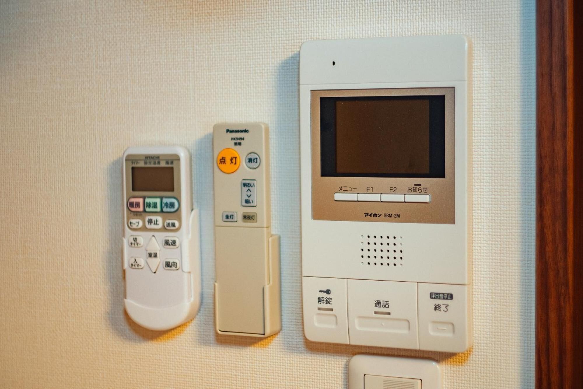 A Panasonic electronic device with a screen and buttons, a smaller remote control, and a keypad.