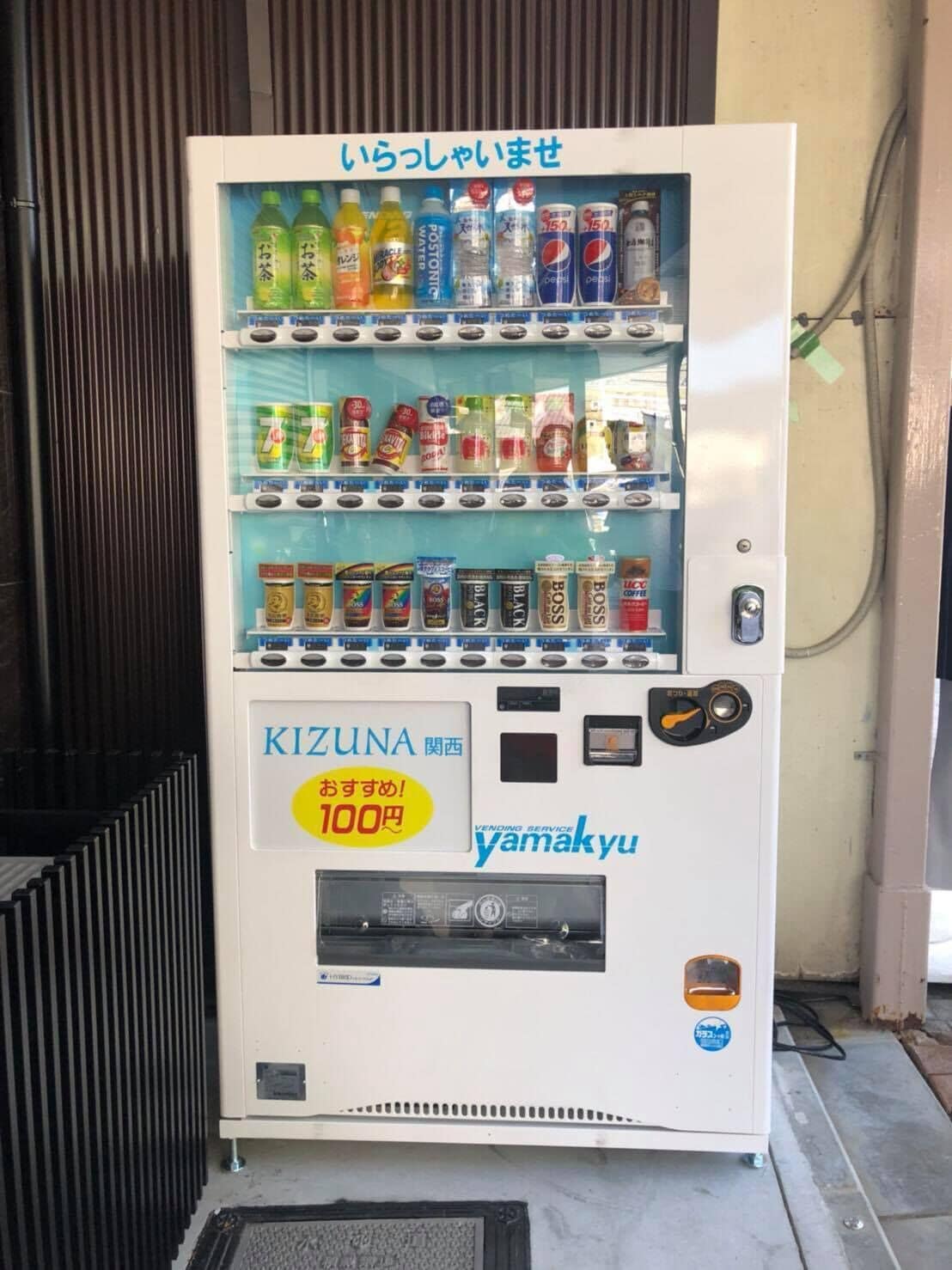 A vending machine with various drinks and snacks, labeled with 'KIZUNA' and 'yamakyu'.