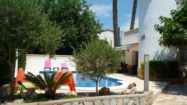 A pool area with a stone wall, a small tree, and a building with a white exterior. - ESCALA, 5 minutes walk beach, VILLA STANDING160 habitab m2 / WIFI / WDM POOL  (L'Escala)