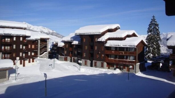 A snow-covered building with a ski lift in the background.