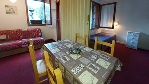 A small, cozy room with a dining table, two chairs, a sofa, and a bed. - Quiet apartment in Valmorel, pets allowed, 5 people (Valmorel)