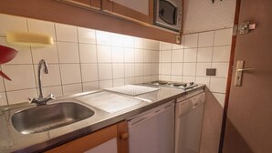 A compact kitchen with a sink, a microwave, and a dishwasher. - Quiet apartment in Valmorel, pets allowed, 5 people (Valmorel)