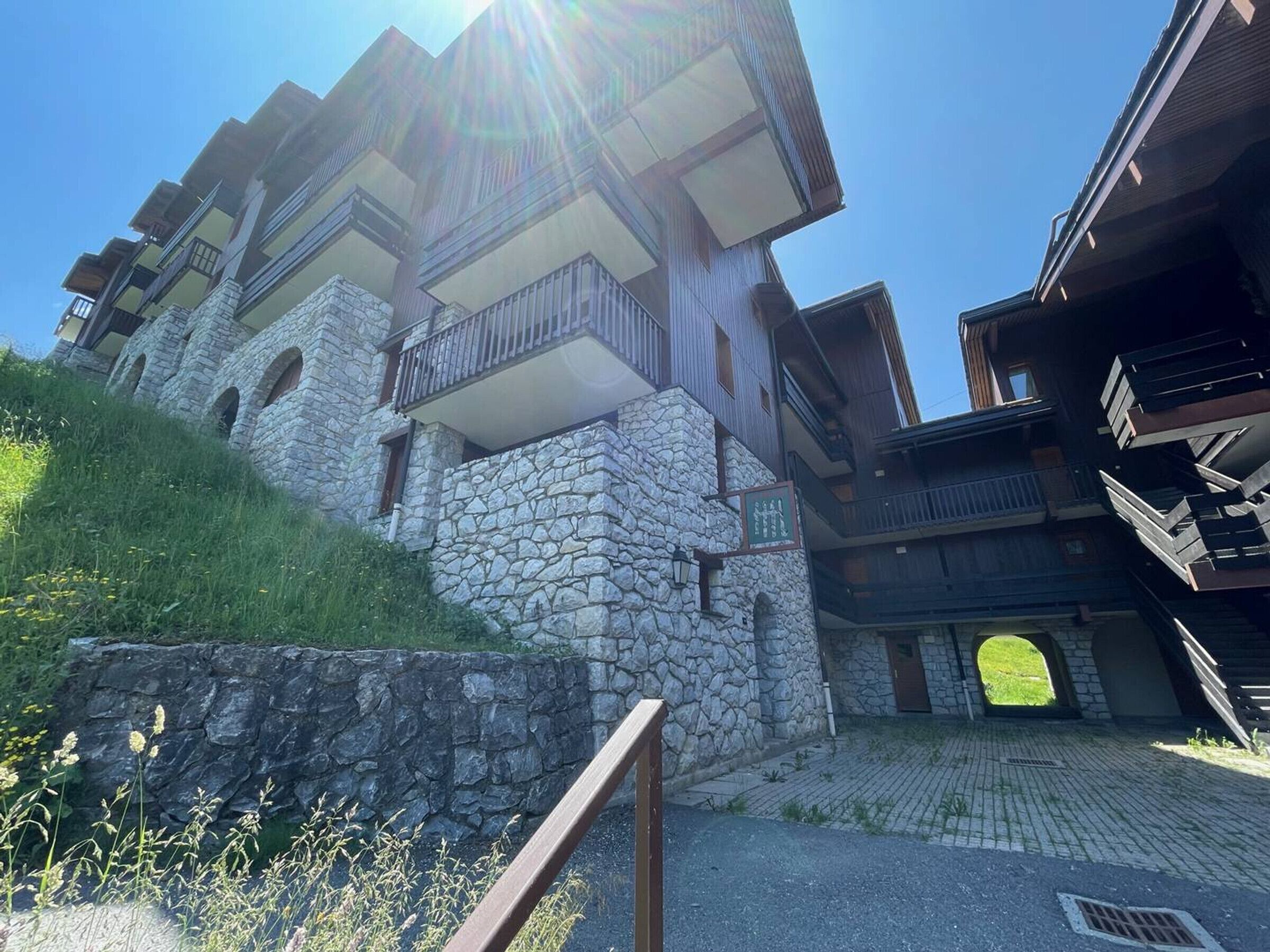 Um edifício com várias andares, fachadas de pedra e varandas.