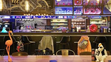 Eine Bar mit Tresen, Stühlen und einem Tisch mit Flamingodekoration.