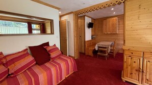 Ein gemütliches Zimmer mit einem Bett, einem kleinen Tisch und Holzschränken.