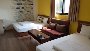 A hotel room with a bed, a sofa, a small table, and a wall with street signs. - Shimmer B&B (Magong)