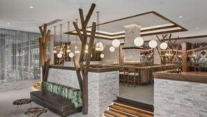 Un interior moderno con una zona de bar, asientos y una escalera.