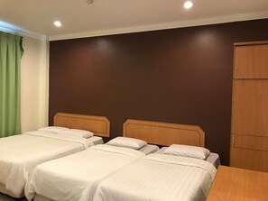 A hotel room with two single beds, a wooden wardrobe, and a green curtain. - Kangsar Hotel (Kuala Kangsar)