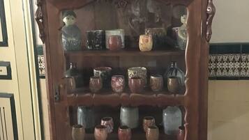 A wooden cabinet with ornate carvings and multiple shelves holding various ceramic items.