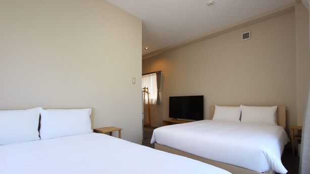 A hotel room with two single beds, a television, and a small table. - JUSTIN FUKUOKA (Fukuoka)