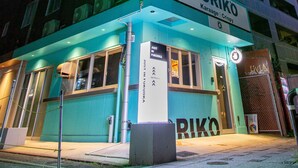 A building with a prominent neon sign reading "JUSTIN FUKOKA" and a smaller sign for "TORIKO". - JUSTIN FUKUOKA (Fukuoka)
