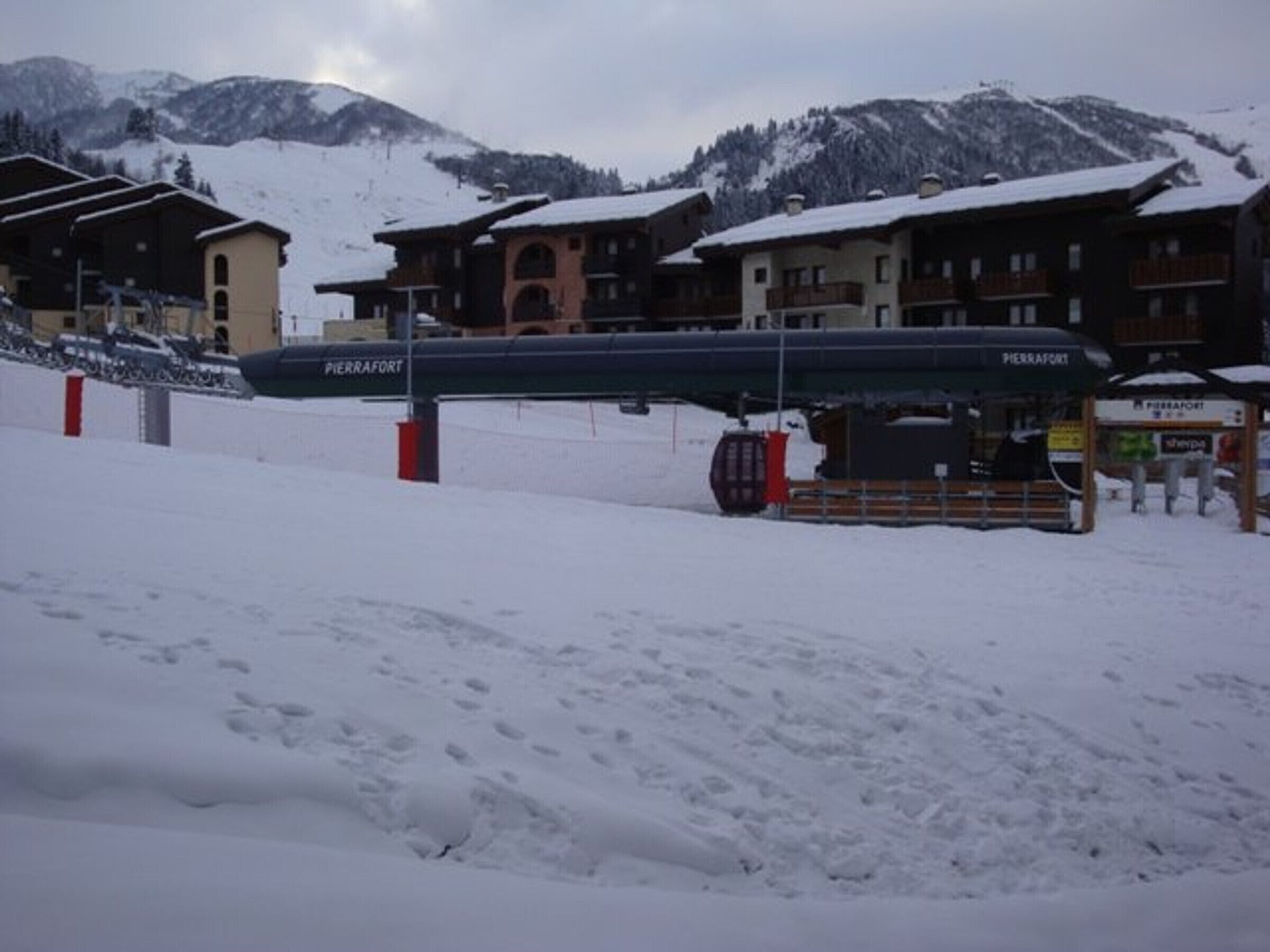 Une station de ski comprenant plusieurs bâtiments, dont un restaurant appelé « Pierrafort », et un télésiège visible au premier plan.