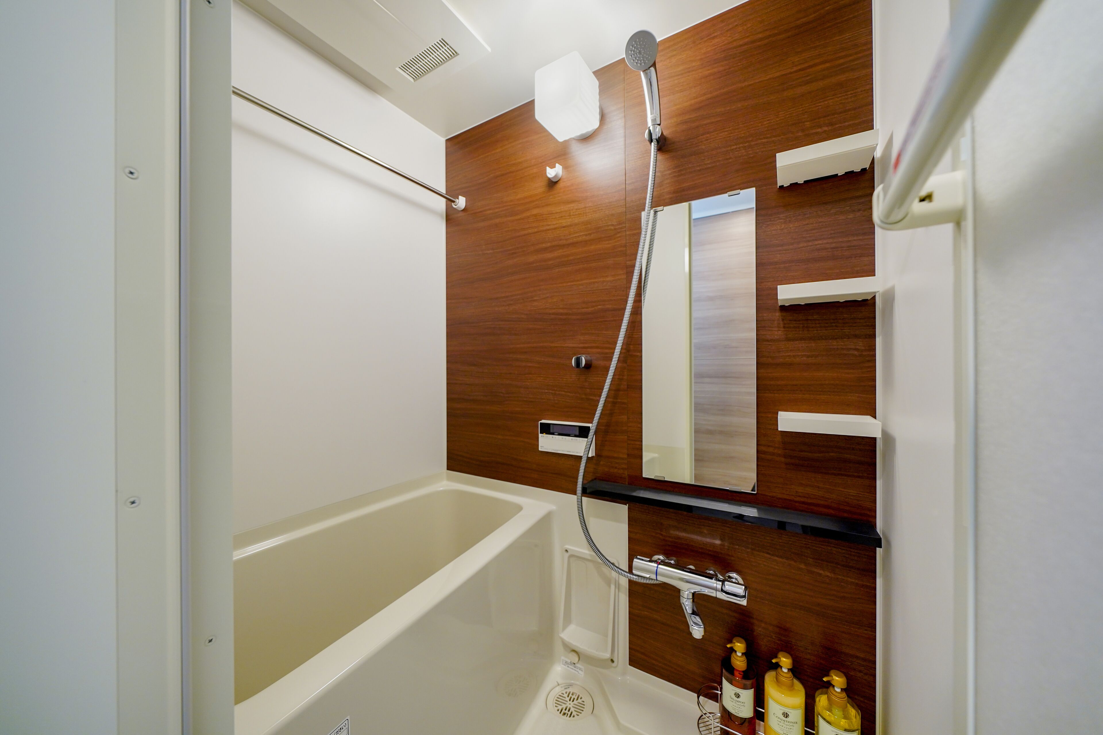 A modern bathroom with a wooden vanity, a bathtub, and a shower.