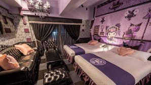 A hotel room with two beds, a black leather sofa, a matching ottoman, a chandelier, and a wall with owl-themed decorations. - RESI STAY THE KYOTO (Kyoto)