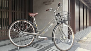 A bicycle parked in front of a building with a sign that reads "RESIST STAY THE KYOTO." - RESI STAY THE KYOTO (Kyoto)