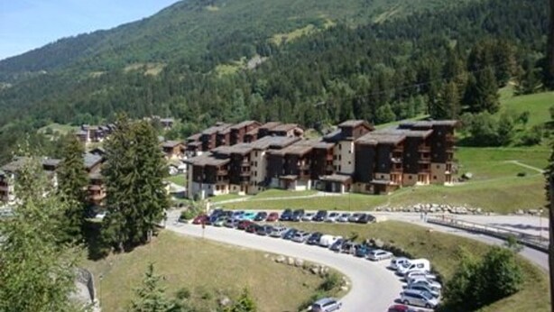 A mountain lodge with multiple buildings, a parking lot, and a road leading to the lodge. - Divisible studio 4ppl, ski-in/ski-out, pets allowed - Valmorel (Valmorel)
