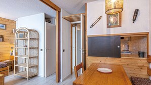 A cozy room with a wooden dining table, chairs, a metal shelf, and a chalkboard wall. - Divisible studio 4ppl, ski-in/ski-out, pets allowed - Valmorel (Valmorel)