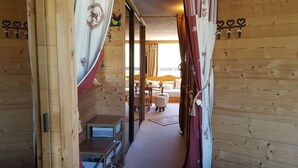 A wooden interior with a bed, a small table, and a chair.