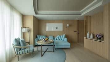 A modern living room with a sofa, armchair, and round coffee table.
