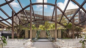 An outdoor wedding venue with a circular stage, white chairs, and decorative floral arrangements. - Hong Kong Ocean Park Marriott Hotel (Hong Kong)