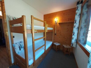 A bunk bed room with a small table and a wall-mounted lamp. - Valmorel - Cozy apartment for 4, direct access to slopes (Valmorel)