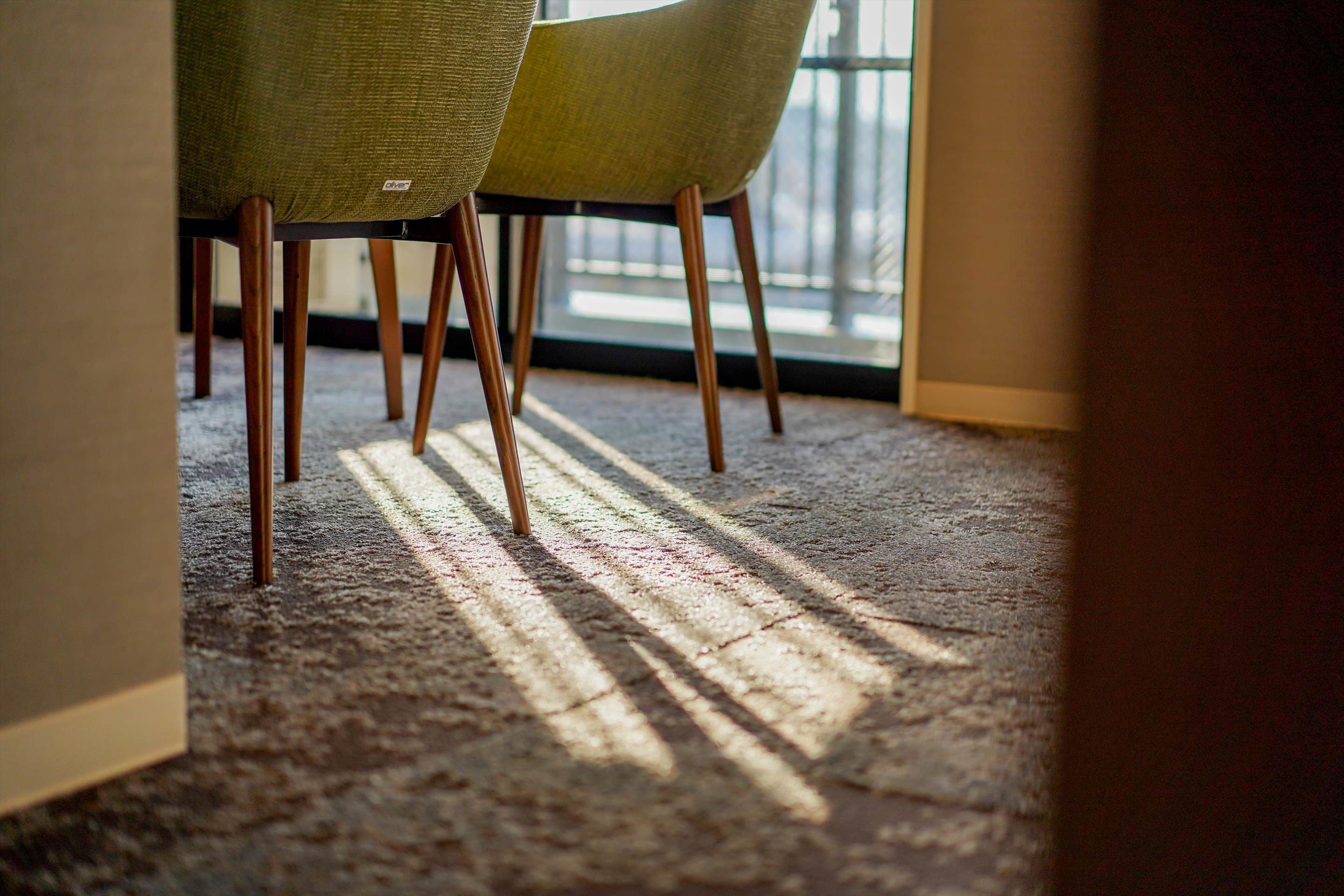 A carpeted floor with sunlight casting shadows through a window.