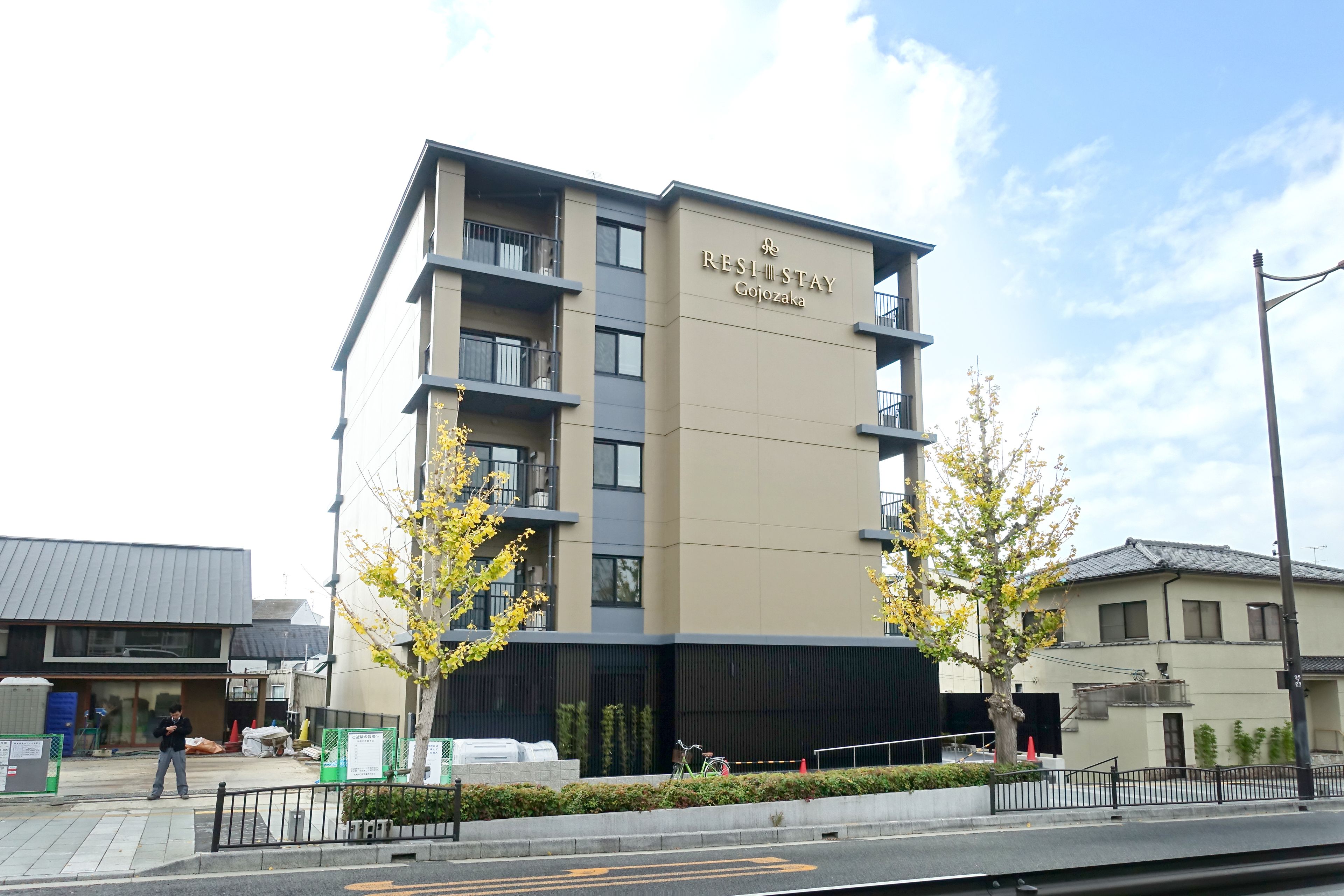 A multi-story building with a sign reading "RESI STAY Gojozaka".