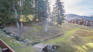 A hillside view with a wooden bridge, a grassy area, and a row of buildings in the background. - 27m² studio with balcony, pets allowed, near lifts (Valmorel)