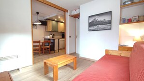 A compact living space with a kitchenette, a dining area, and a sofa. - 27m² studio with balcony, pets allowed, near lifts (Valmorel)