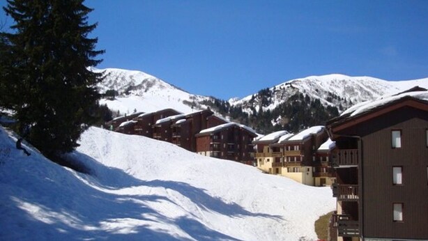 A snow-covered mountain with a ski resort building featuring multiple balconies and a ski lift in the background. - 27m² studio with balcony, pets allowed, near lifts (Valmorel)