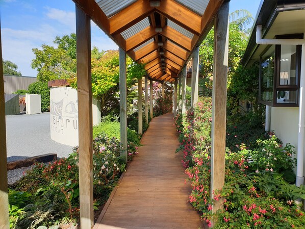 A wooden pathway under a covered structure with a sign reading "MAHUR RETREAT".