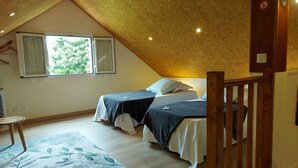 A bedroom with two beds, a wooden ceiling, and a window with shutters. - Furnished house in a flower garden for a stay with family and friends (Saint-André)