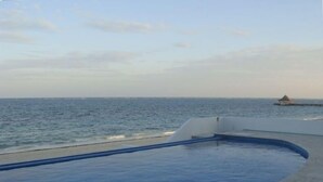 A swimming pool with a view of the ocean and a distant island. - GREAT PLACE !!!! GREAT PRICE!!!!  WONDERFUL VIEW !!!!   (Puerto Morelos)