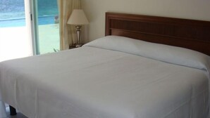 A neatly made bed with a wooden headboard in a hotel room. - GREAT PLACE !!!! GREAT PRICE!!!!  WONDERFUL VIEW !!!!   (Puerto Morelos)