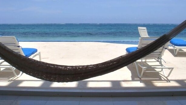 A beach view with a hammock, lounge chairs, and a clear blue ocean. - GREAT PLACE !!!! GREAT PRICE!!!!  WONDERFUL VIEW !!!!   (Puerto Morelos)