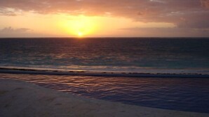 A beach with the sun setting over the ocean. - GREAT PLACE !!!! GREAT PRICE!!!!  WONDERFUL VIEW !!!!   (Puerto Morelos)