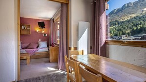 Una habitación acogedora con cama, escritorio y vistas a un paisaje montañoso.