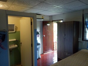 A room with a bathroom, a wardrobe, and a door leading to another room. - Phaiwan Baansawn Resort (Chai Nat)