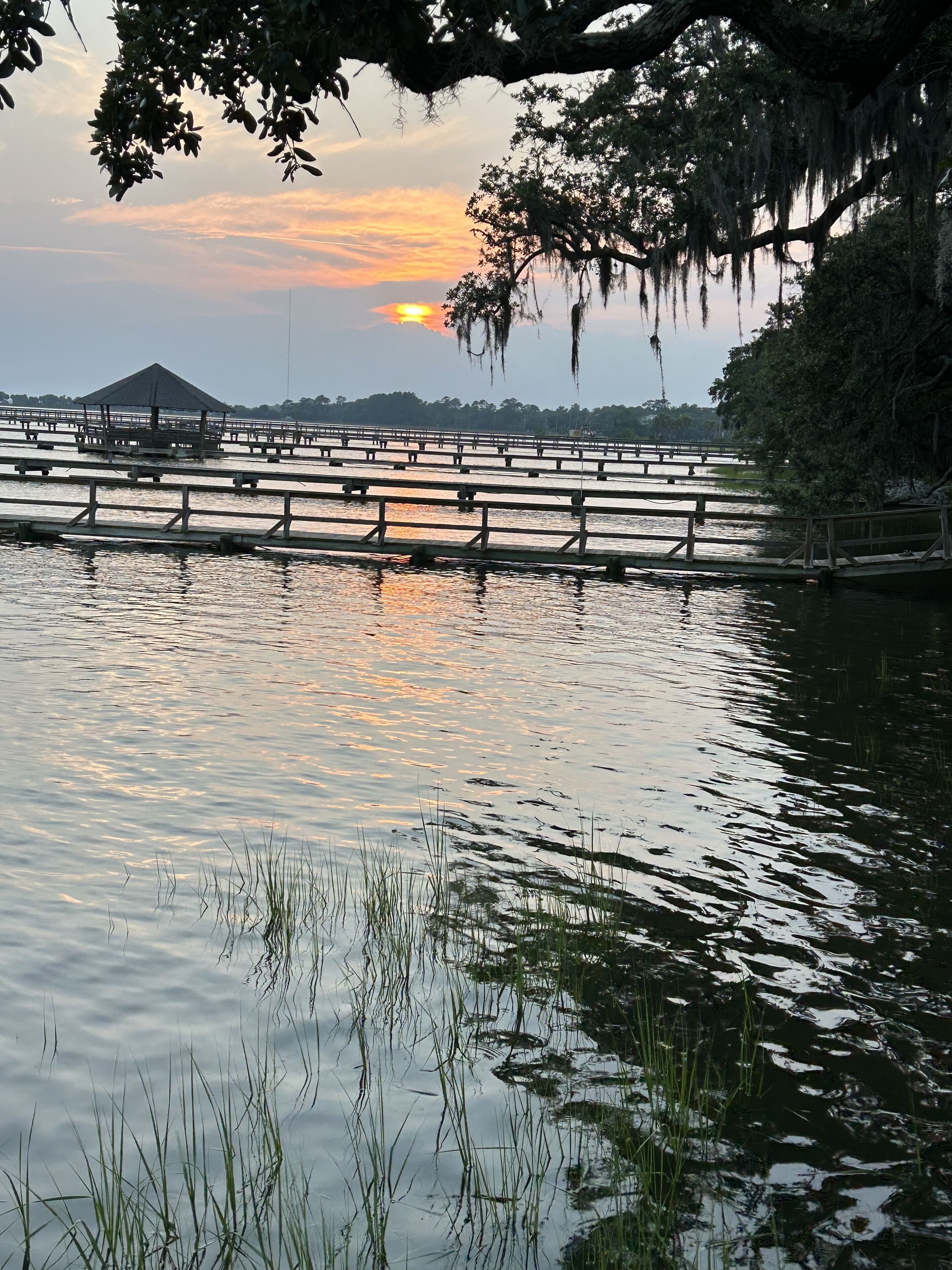 A tranquil lakeside setting with wooden walkways and a gazebo.