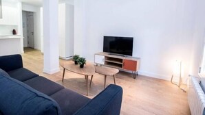 A modern living room with a sofa, a coffee table, and a TV stand. - Bright apartment T3 (Tours)