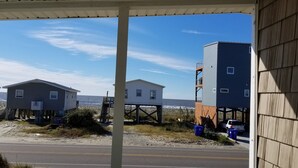 Propiedad frente a la playa con casas elevadas y un área techada.