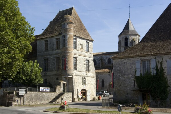 A historic stone building with a central tower and a smaller tower to the right. - Gite with private pool for 6 people in a privileged site (Plaisance)