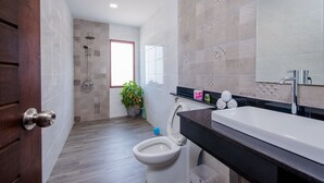 Une salle de bain moderne équipée d’une douche, de toilettes et d’un lavabo.
