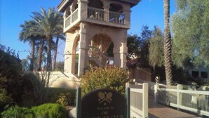 A building with a balcony and a sign that reads "Welcome to the Racquet Club". - Modern top floor corner unit with pool view  (Scottsdale)