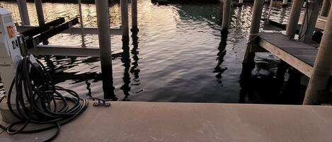 Un port de plaisance avec des bateaux amarrés, un quai en béton et une pompe à eau.